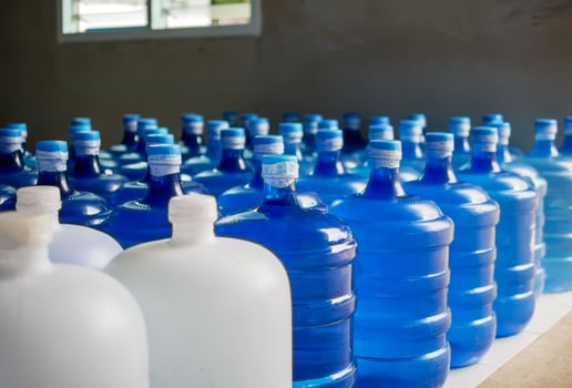 plastic big bottles or white and blue gallons of purified drinking water inside the production line. Water drink factory photo