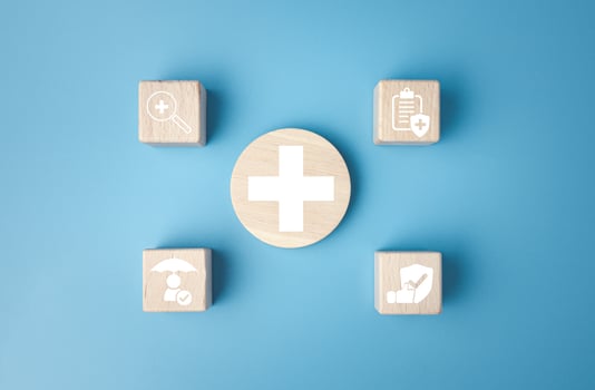 Concept of health insurance and medical. Wooden block with icons about health insurance and access to health care, health care planning on a blue background. photo