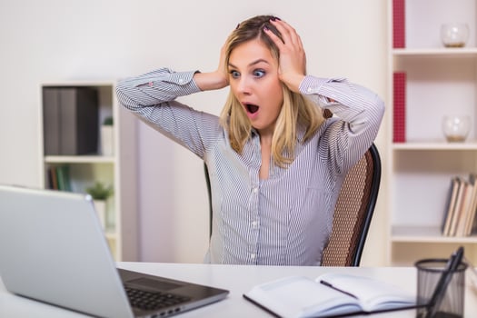 Businesswoman in panic looking at laptop while working in her offic photo