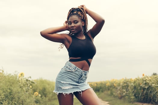 African American girl in a field of yellow flowers at sunset photo