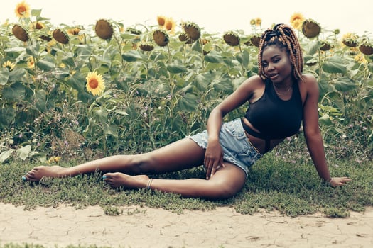 African American girl in a field of yellow flowers at sunset photo