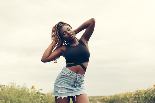 African American girl in a field of yellow flowers at sunset photo