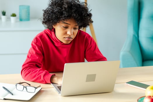 African american girl using laptop at home office looking at screen typing chatting reading writing email. Young woman having virtual meeting online chat video call conference. Work learning from home photo