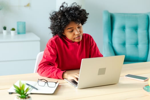 African american girl using laptop at home office looking at screen typing chatting reading writing email. Young woman having virtual meeting online chat video call conference. Work learning from home photo