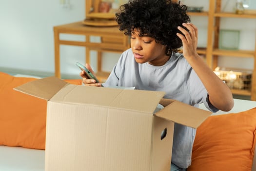 Unhappy african woman unpack delivered box receiving damaged shipping problem in postal service. Annoyed confused customer receiving wrong parcel talks to customers support. Bad delivery services photo