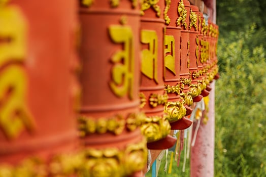 Rotating religious elements for touching turning spinning Buddhist prayer wheel at Buddhist monastery. Prayer wheels in Buddhist stupa temple. Buddhism religion concept. photo