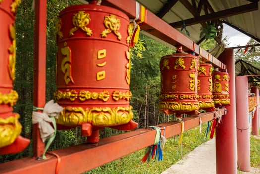 Rotating religious elements for touching turning spinning Buddhist prayer wheel at Buddhist monastery. Prayer wheels in Buddhist stupa temple. Buddhism religion concept. photo