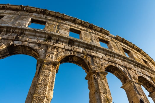 Ancient Roman amphitheater with blue sky on the background photo