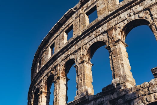 Ancient Roman amphitheater with blue sky on the background photo