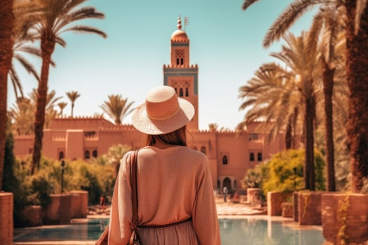 Young woman in a straw hat on the background of the city of Marrakech, Morocco, rear view of a Woman looking at Koutoubia mosque minaret-Tourism in Marrakech, Morocco, AI Generated photo