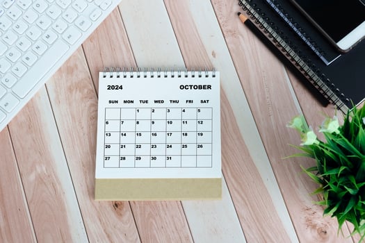 White October 2024 calendar on office wooden desk. photo