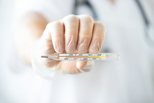 Doctor's hand with thermometer photo