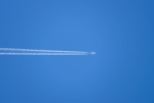 Condensation trail from an airplane in a blue sky photo