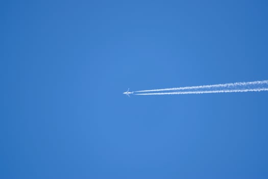 Condensation trail from an airplane in a blue sky photo