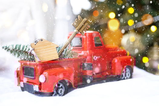 Red retro car with a Christmas tree decorates with the house key in the pickup truck for Christmas. Buying a home, moving, mortgage, loan, real estate, festive mood, New Year photo