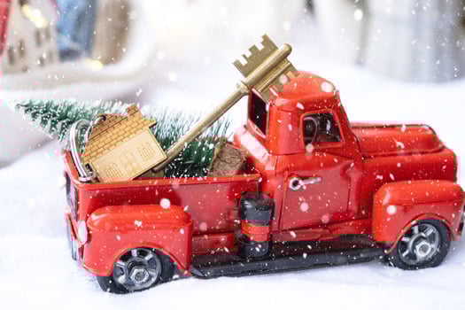 Red retro car with a Christmas tree decorates with the house key in the pickup truck for Christmas. Buying a home, moving, mortgage, loan, real estate, festive mood, New Year photo