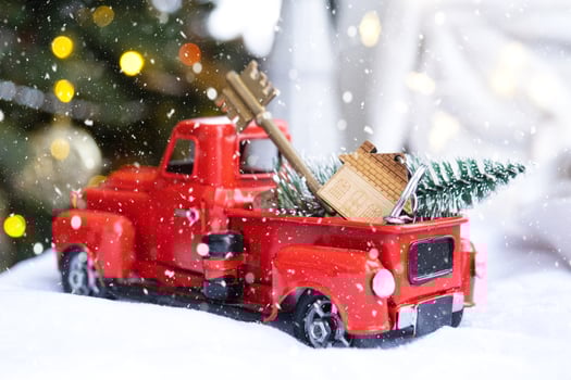 Red retro car with a Christmas tree decorates with the house key in the pickup truck for Christmas. Buying a home, moving, mortgage, loan, real estate, festive mood, New Year photo