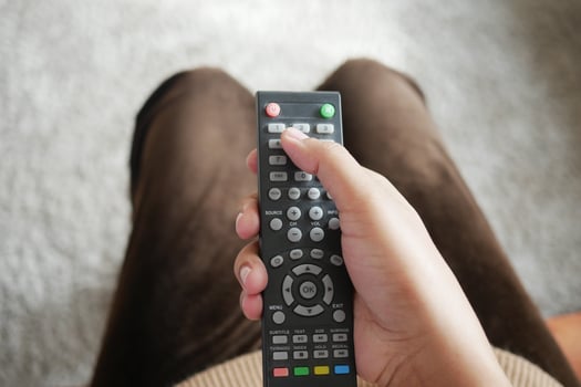 close up of women hand holding tv remote. photo
