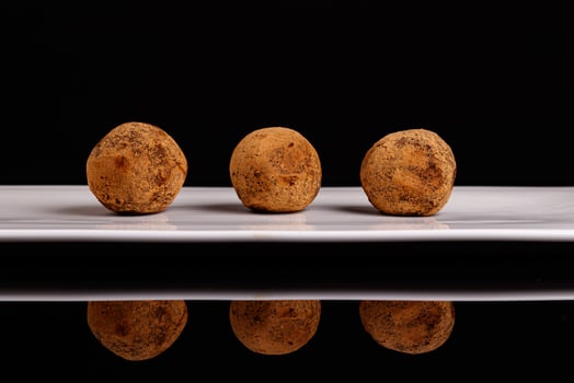 Beautiful candy truffle on a white plate on a black background photo