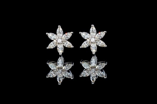 beautiful gold earrings with diamonds gemstones on a black background photo