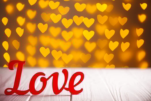 the inscription Love on a wooden background with beautiful hearts made of lights on a blurred background photo