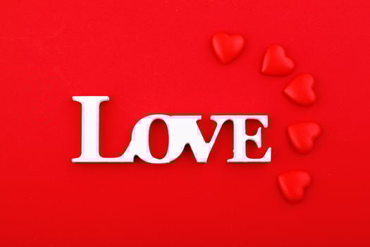 inscription love and red hearts on a red background photo