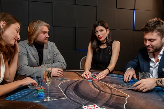 Confident brunette raking chips after successful poker game in casino photo