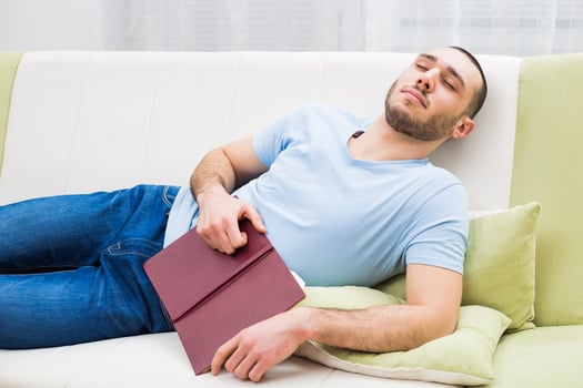 Young man fell asleep while reading a book photo