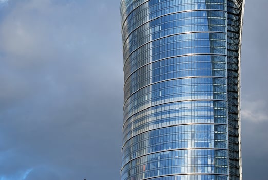 Structural glass wall reflecting blue sky. Abstract modern architecture fragment. photo