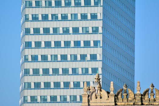 Structural glass wall reflecting blue sky. Abstract modern architecture fragment. photo
