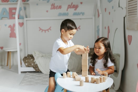 children boy and girl play with wooden toys at home in children's bedroom photo