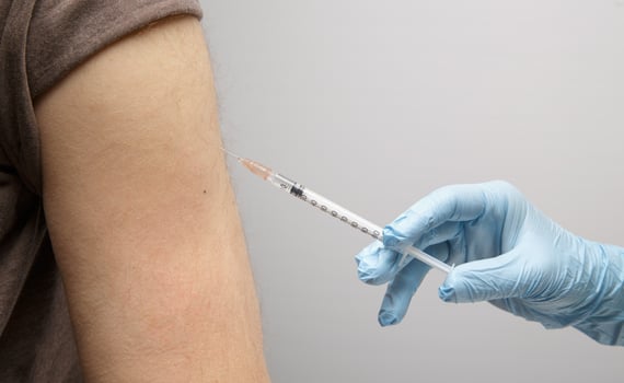 the hand of a paramedic makes an injection of a vaccine to an invisible person. health concept. protection against coronavirus photo