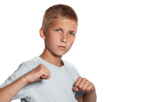 Close-up portrait of a blonde teenage boy in a white t-shirt posing isolated on white studio background. Concept of sincere emotions. photo