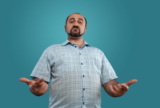 Close-up portrait of a brunet middle-aged man with beard, dressed in a light checkered shirt and posing against a blue background. photo