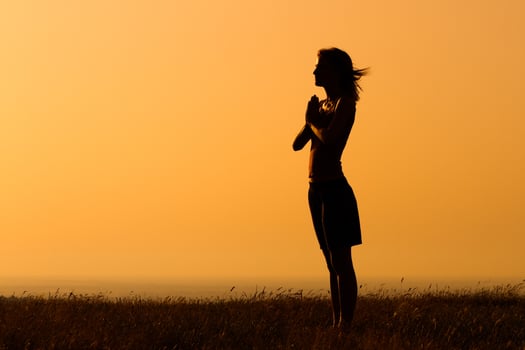 Silhouette of a  woman meditating in the nature photo
