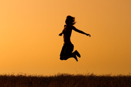 Silhouette of happy  woman jumping in the nature photo