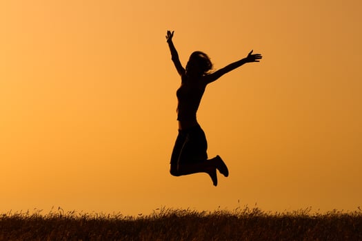 Silhouette of happy  woman jumping in the nature photo