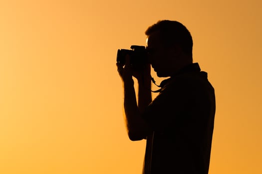 Silhouette of a man photographing photo