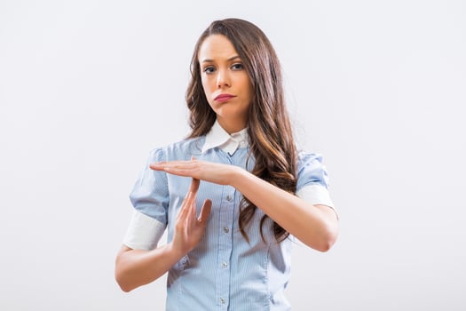 Image of tired businesswoman showing time out sign on gray background photo
