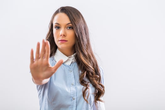 Image of serious businesswoman showing stop sign on gray background photo