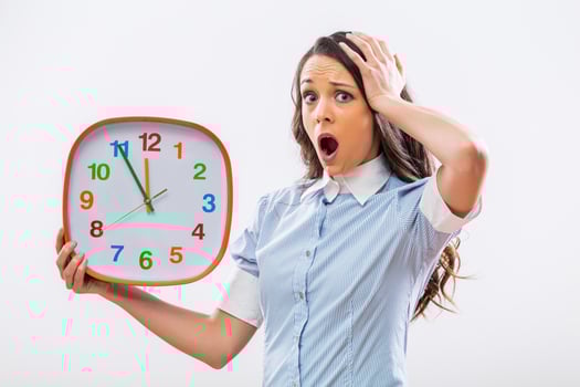 Image of businesswoman in panic holding clock on gray background photo