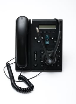 Black desktop phone with a headset on the white background photo