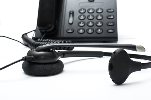 Black desktop phone with a headset on the white background photo