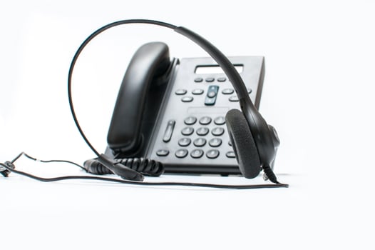 Black desktop phone with a headset on the white background photo