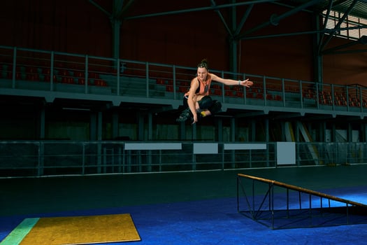 The young woman performs a trick. Jump. Indoor training photo