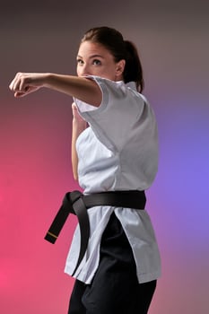 Athletic woman in traditional kimono is practicing karate in studio. photo