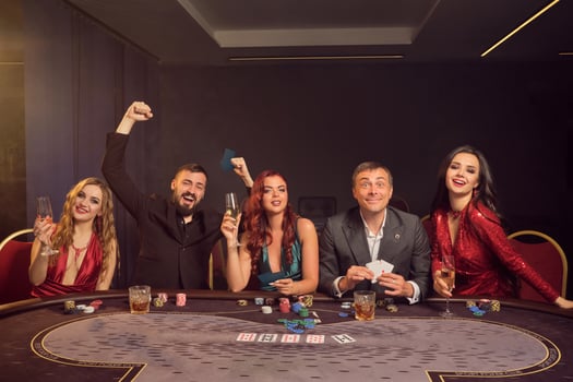 Group of a young wealthy friends are playing poker at a casino. photo