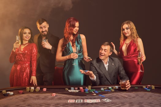 Group of a young wealthy friends are playing poker at a casino. photo