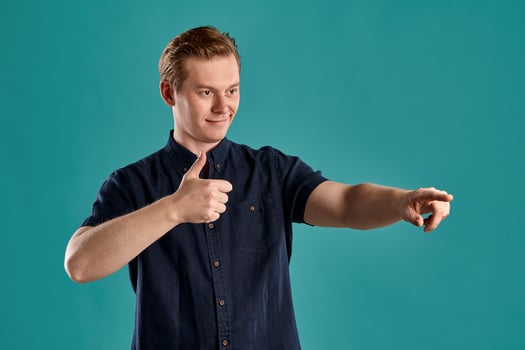 Close-up portrait of a ginger guy in navy t-shirt posing on blue background. Sincere emotions. photo