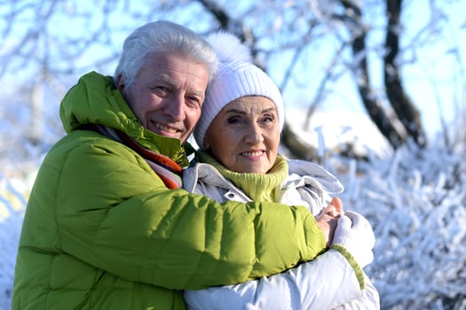 Close up portrait of happy senior couple at snowy winter park photo